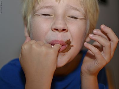 Ein Junge genießt Schokolade. 