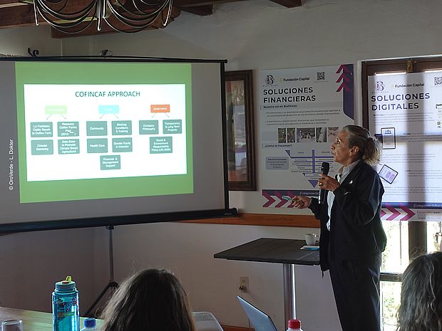 María Ester Saut Niño, Mitgründerin der Kooperative Cofincaf, erklärt anhand einer PowerPoint-Präsentation den Ansatz der Kooperative für biodiversitätsfreundliche Landwirtschaft.