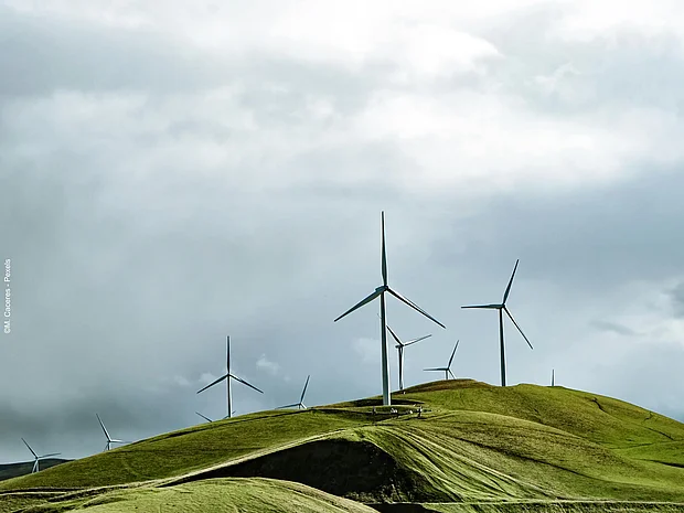 Ein Windpark in hügeliger Landschaft.