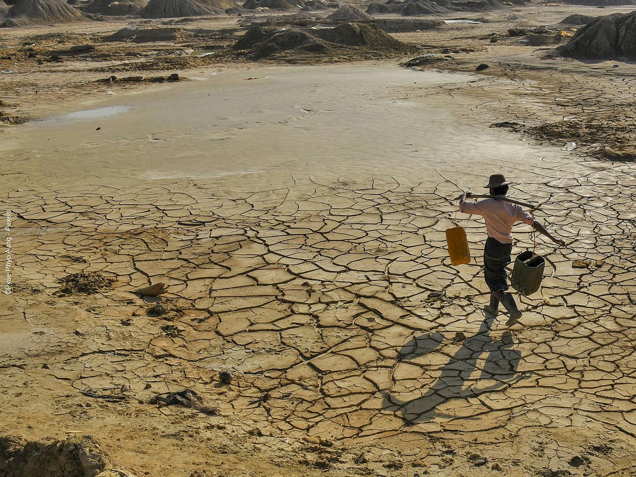 Eine Person läuft über ausgedörrten Boden. 