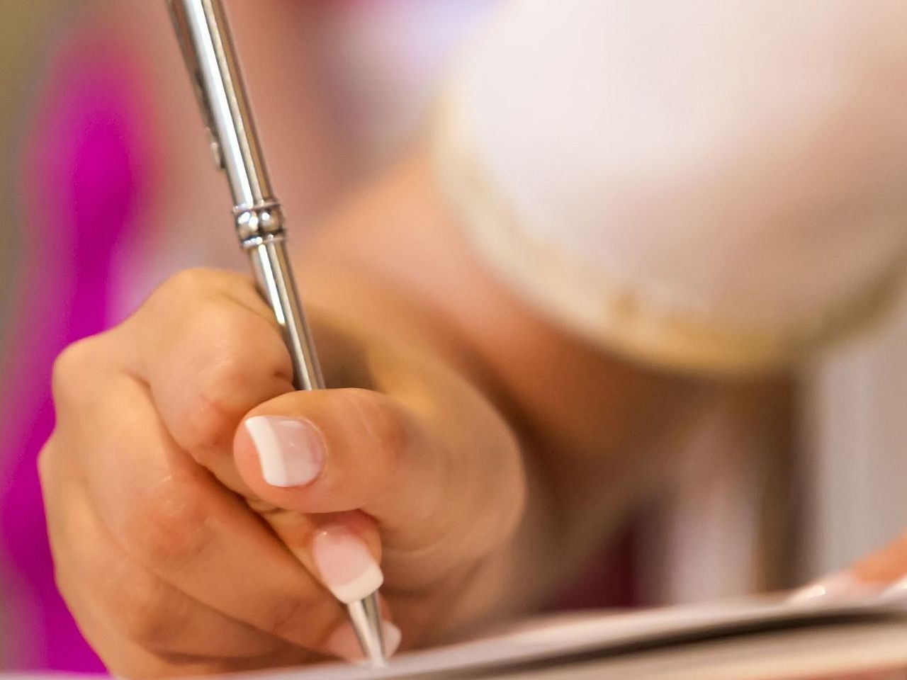 Hand mit Stift unterschreibt