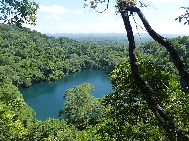 Blick von oben auf einen See umgeben von Bäumen im Nationalpark Sierra del Lacandón in der Selva Maya