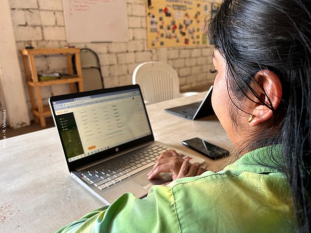Eine Frau sitzt vor einem Laptop, auf dem Sirio geöffnet ist.