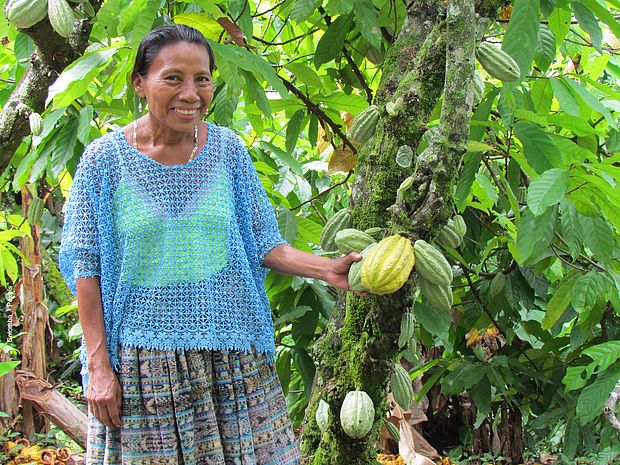 Eine Kakaobäuerin neben einem ihrer Bäume. 