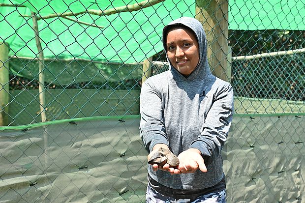 Eine Frau zeigt die Muscheln in ihren Händen.