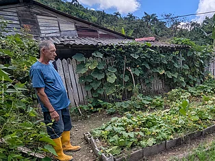 Ein Mann steht vor seinem Hausgarten in einer ländlichen Region Kubas. © OroVerde - K. Osen