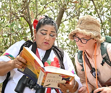 Marina Luz bestimmt mit Hilfe eines Buches eine Vogelart.
