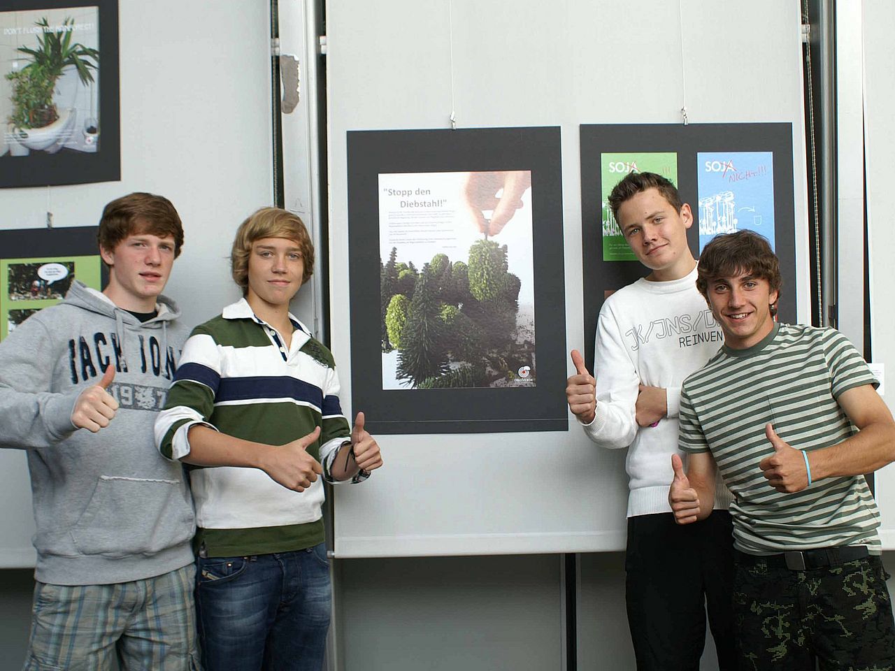 Teilnehmer des Plakatwettbewerbs vor Plakatwand ©OroVerde