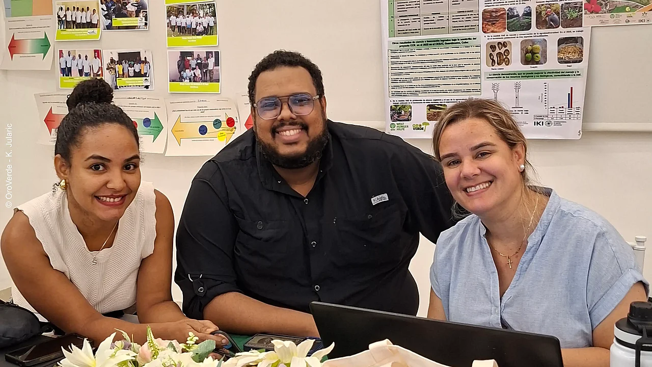 Stephanie Estévez, Emmanuel Batista und Yunaika Álvarez lächeln während einer Arbeitsphase des KlimaWald-Jahrestreffens in die Kamera.
