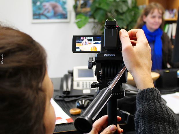 Das Bild zeigt einen Videodreh im Büro von OroVerde, eine Person bedient die Kamera und eine weitere Person mit blauem Schal wird gefilmt. 