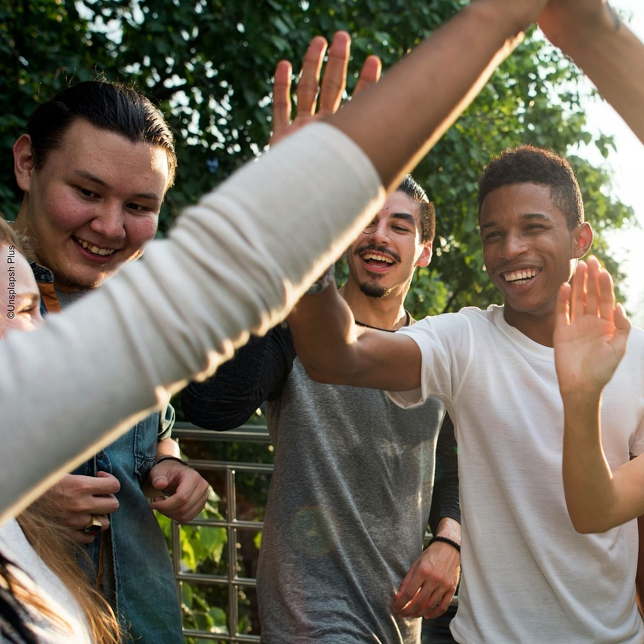 Umdenken und Anpacken ©Alex Krivac - Unsplash Plus Motivierte junge Menschen geben sich ein 'Highfive'