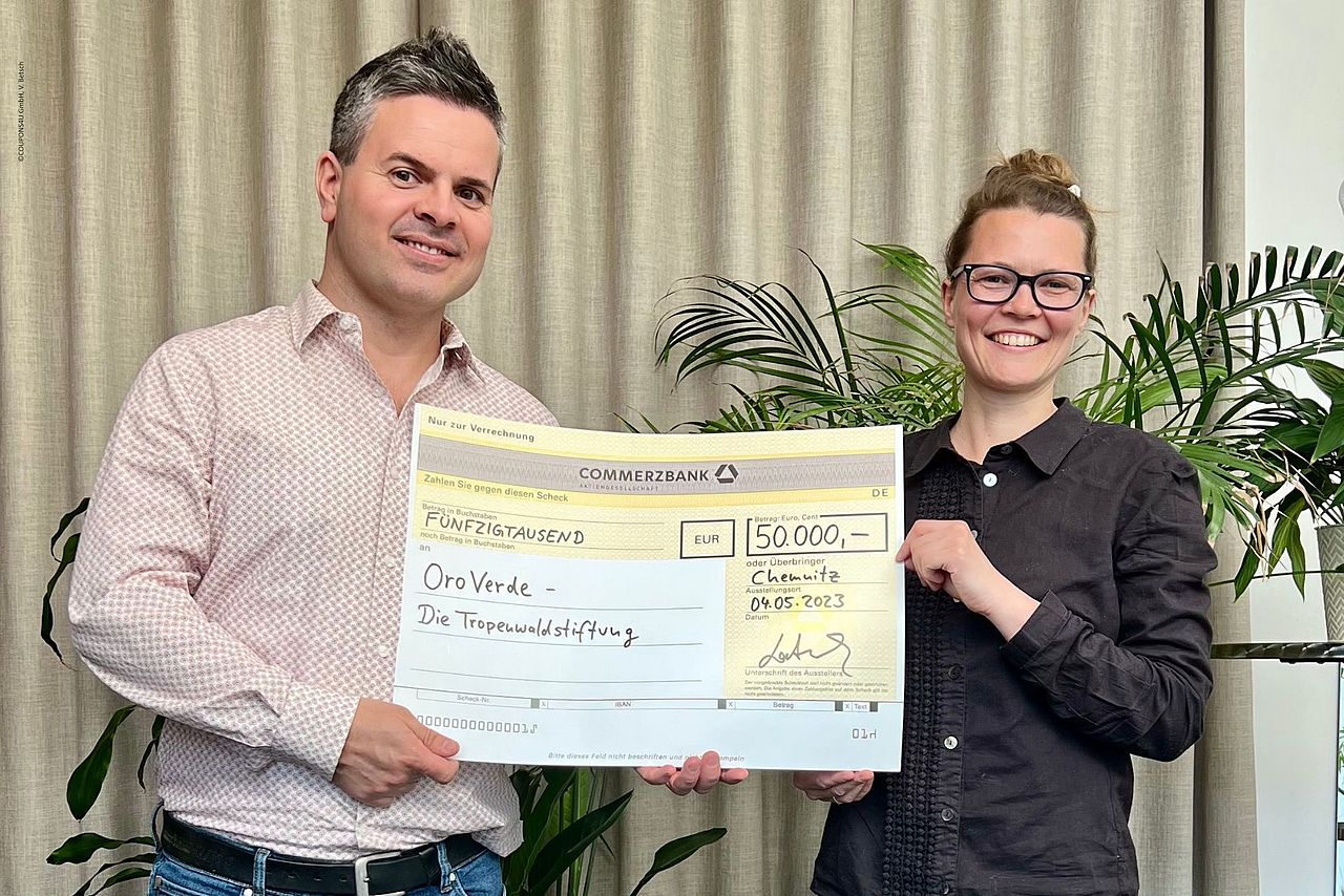 Melissa Brosig aus dem Fundraising von OroVerde nimmt einen Scheck über 50.000 Euro für den Tropenwaldschutz entgegen ©COUPONS4U GmbH, V. Betsch