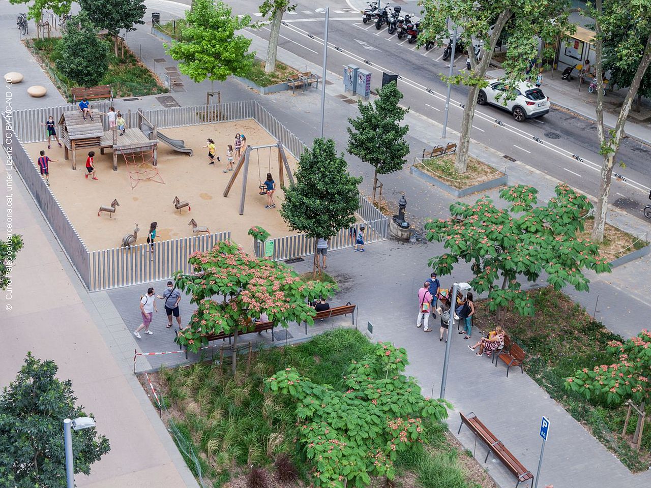 Eine verkehrsberuhigte Zone mit Grünanlage und Spielplatz in Barcelonas Superblocks aus der Vogelperspektive.