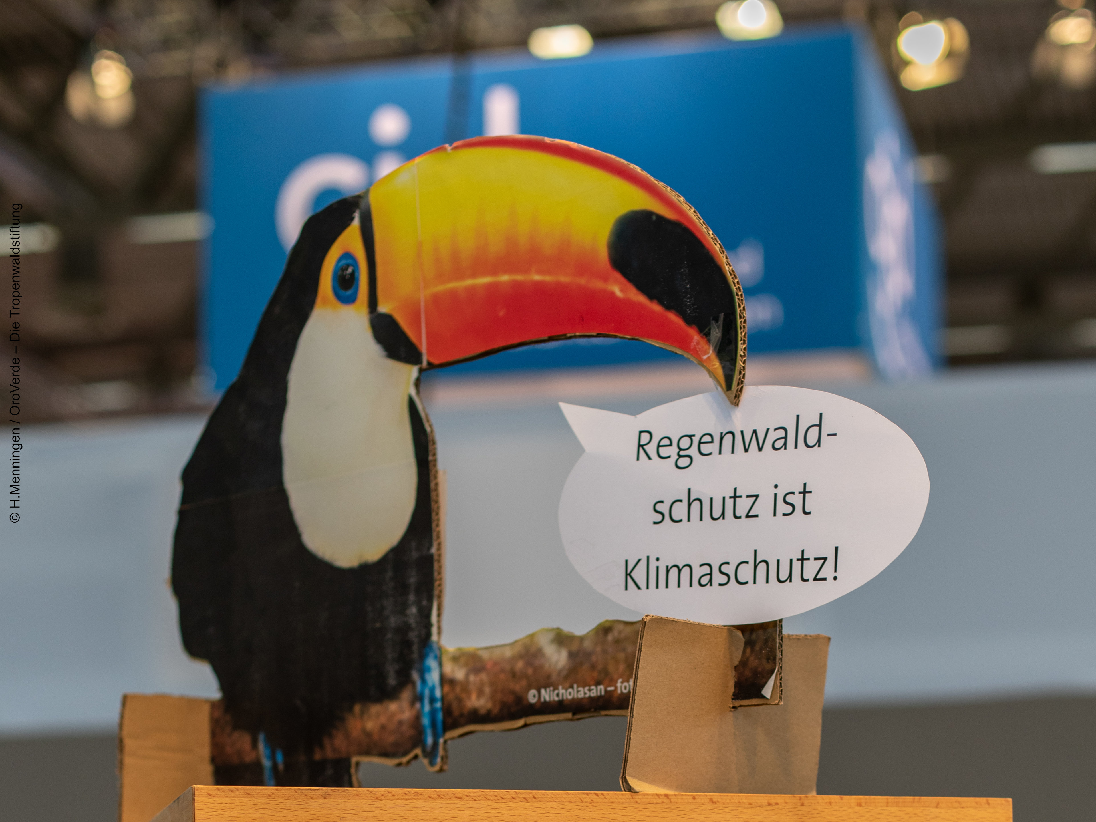 Ein Papp-Austeller mit einem Tukan, der sagt: "Regenwaldschutz ist Klimaschutz"