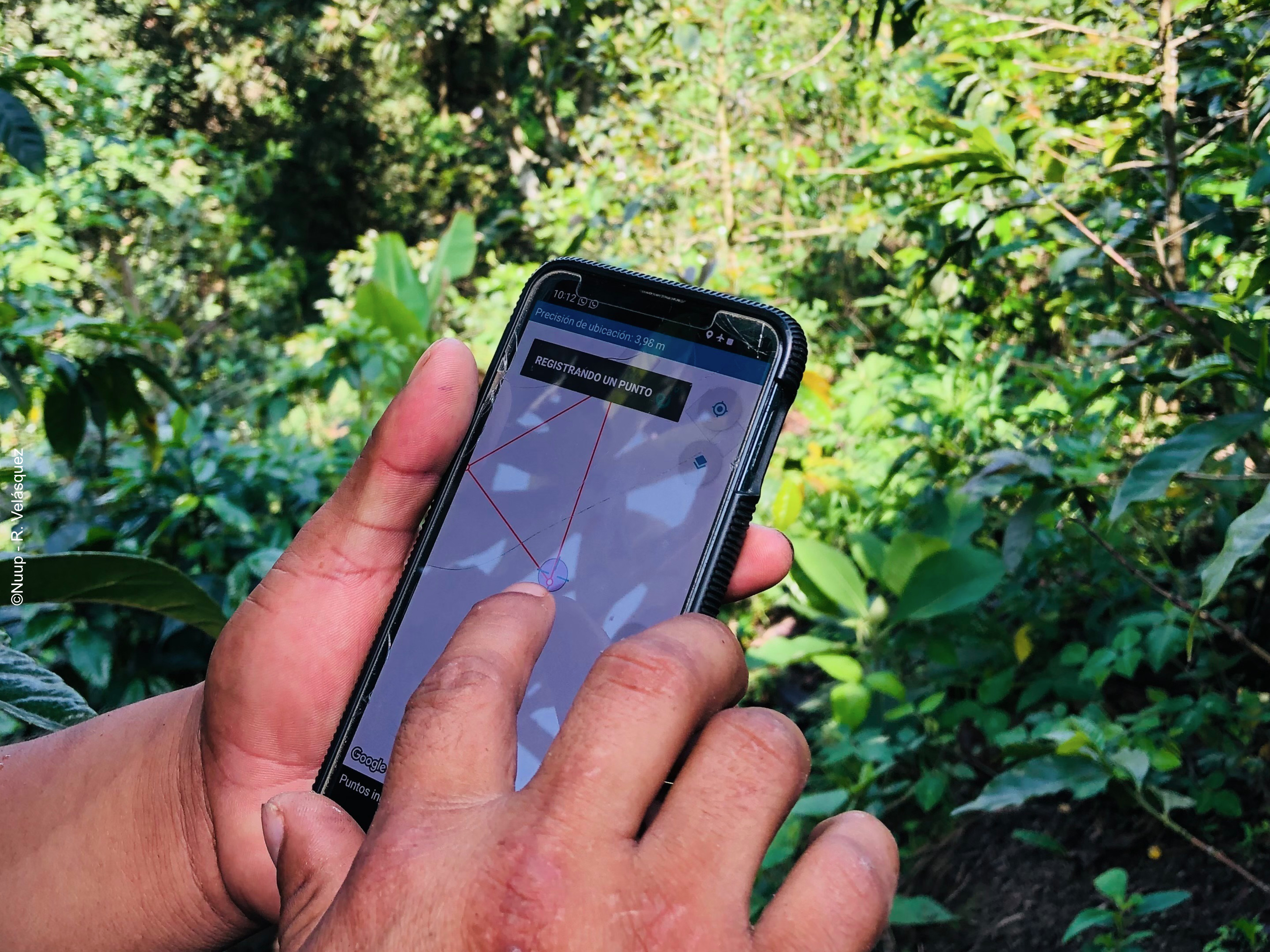 Eine Person hält ein Handy, auf der die App Sirio geöffnet ist. Eine Landkarte ist in der App geöffnet.